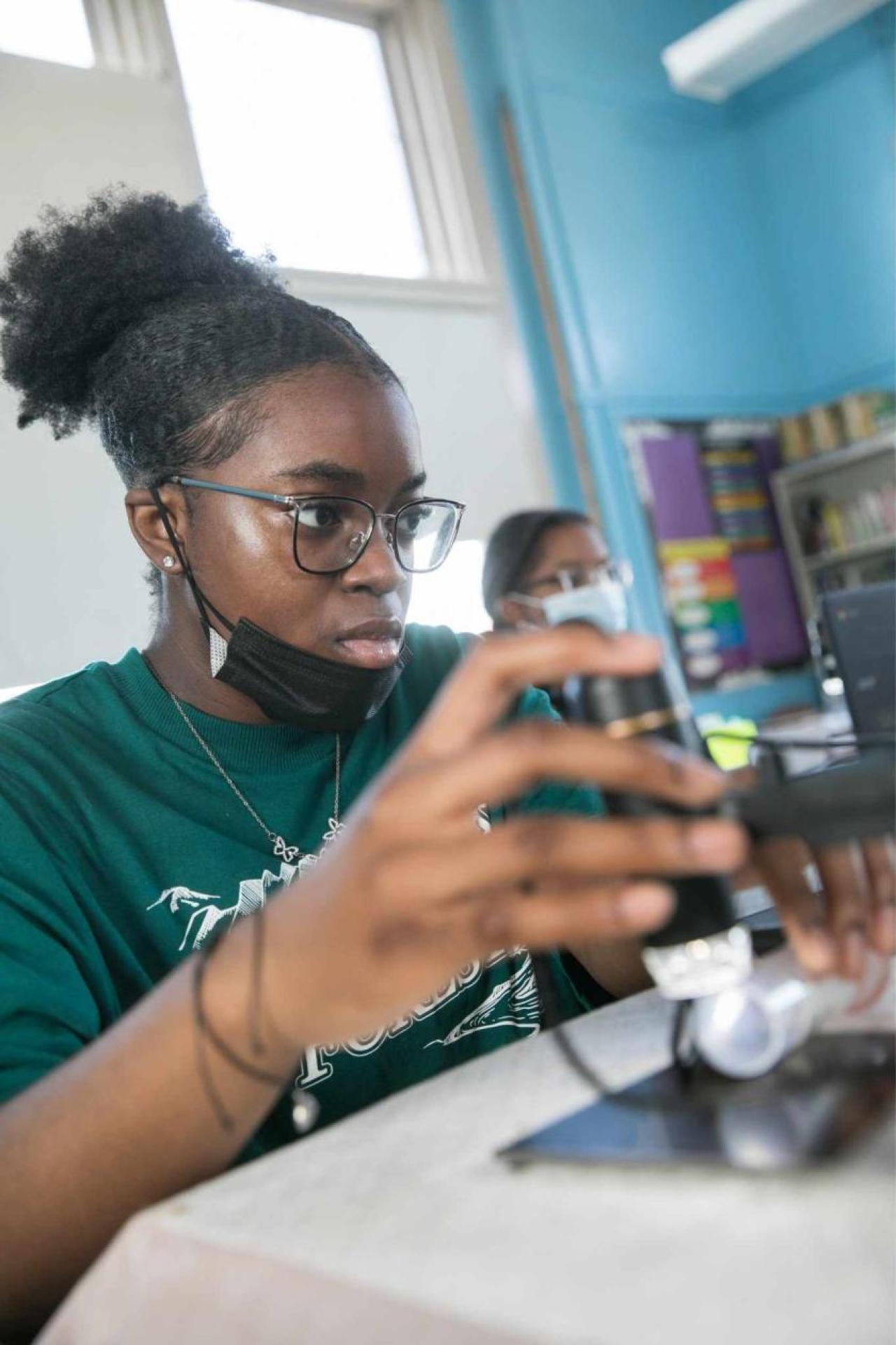 Student in classroom working with micrscope