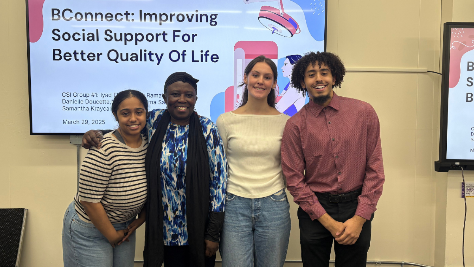Four people standing in front of a tv screen