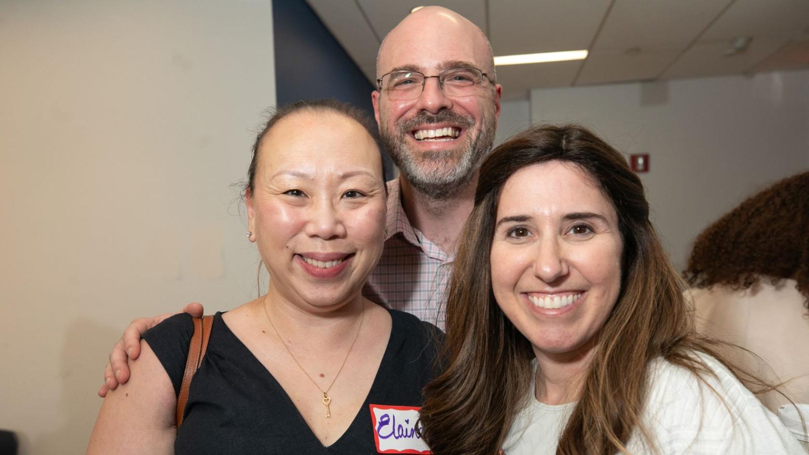 Three people at the survivors' day event smiling at the camera