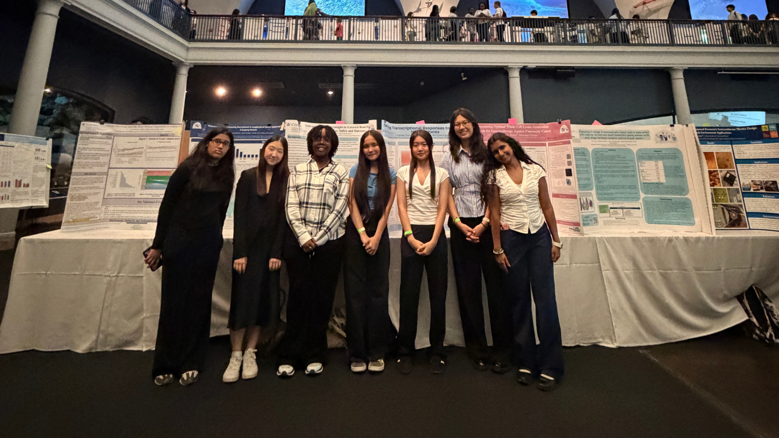 6 students of HICCC's YES in THE HEIGHTS program stand in front of their research presentations.