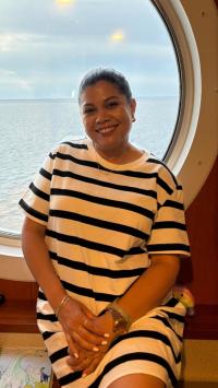 Alondra sitting in front of a window that is looking out onto the water
