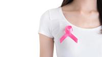 Woman with pink ribbon on her chest, supporting symbol of breast cancer awareness