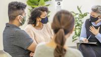 Adults speak with therapist in group setting
