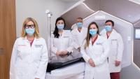 The Department of Radiation Oncology Chair and faculty standing in front of Ethos radiation therapy equipment.