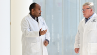Photo of two physicians in white coats in discussion