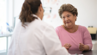 An older patient speaking with their doctor.