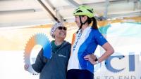 Katherine Crew smiling at a patient on the stage at a Velocity Ride event.