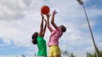 Two young girls playing basketball.