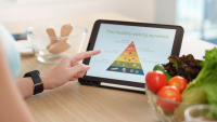 Person on their tablet looking at an image of the food pyramid