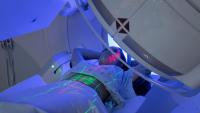 An image of a person getting treatment in a machine with green and red lights on their body.