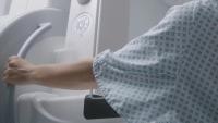 A patient standing in front of a screening machine.
