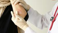 doctor places lotion on person with skin lesion