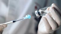 Syringe inserted in a vaccine bottle