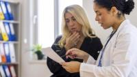 A healthcare professional is going through some paperwork with a patient.
