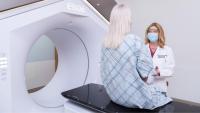 Columbia provider Lisa Kachnic pictures speaking with a patient about to get radiation therapy in Ethos™ Adaptive Radiation Linear Accelerator