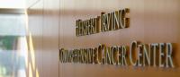 A sign reading herbert irving comprehensive cancer center on a wood paneled wall.