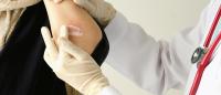 doctor places lotion on person with skin lesion