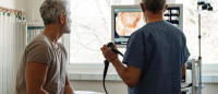 A healthcare provider showing a patient colonoscopy results